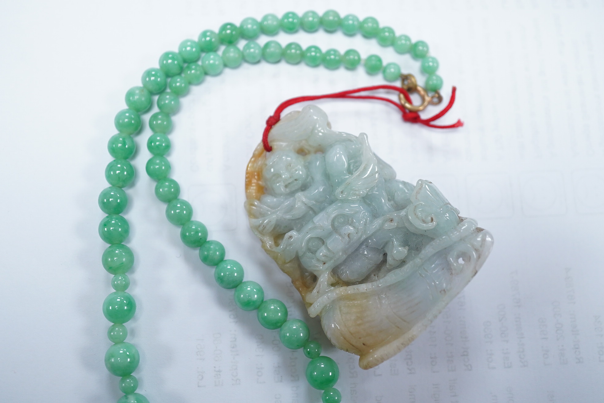 A Chinese jadeite carving and jadeite bead necklace, carving 6.5cm long. Condition - good